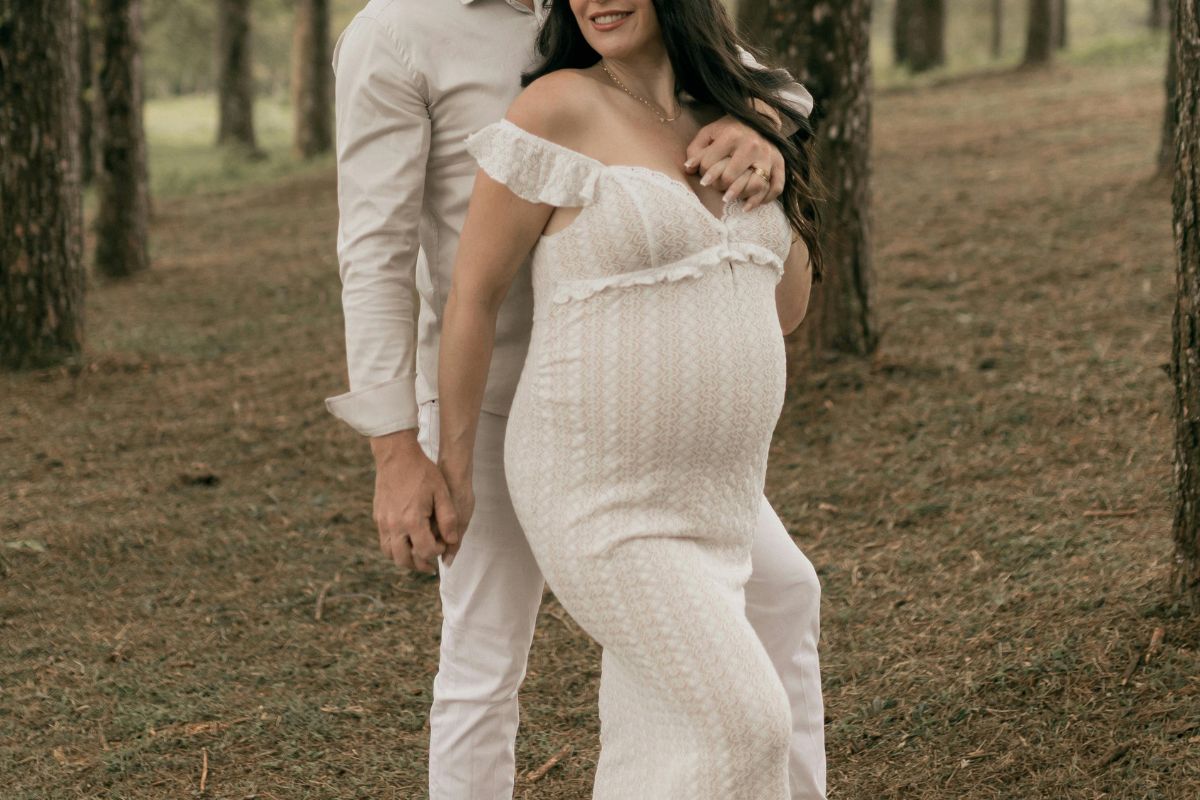 Pregnant couple posing outdoors for romantic babymoon maternity photos.