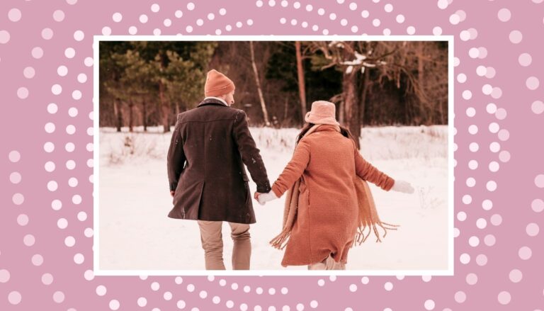 Expecting couple walking through the snow for cozy winter babymoon ideas.