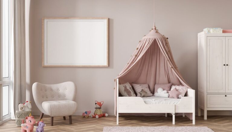 A cozy toddler bedroom featuring a white toddler bed with a pink canopy, soft pillows, stuffed animals, a small armchair, and a white wardrobe.