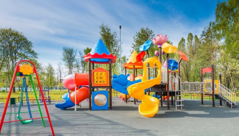 Colorful outdoor playground featuring slides, climbing structures, and swings