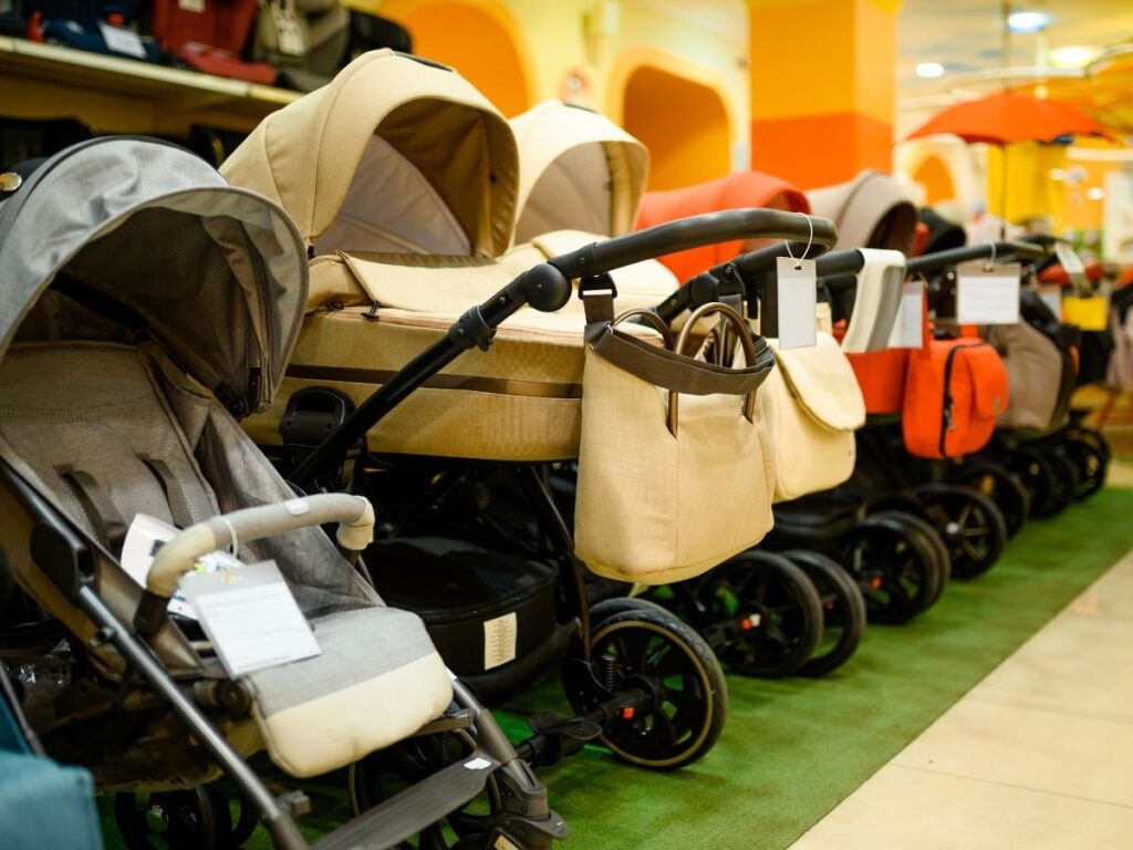 row of strollers with different colors and sizes displayed at a store