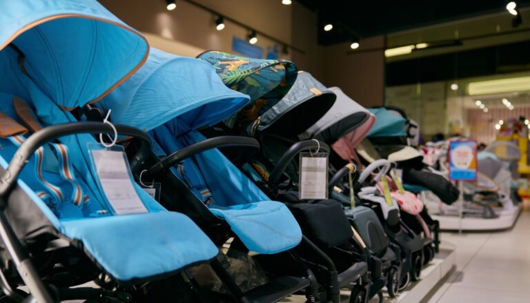Rows of baby strollers displayed in a store for comparison and shopping.