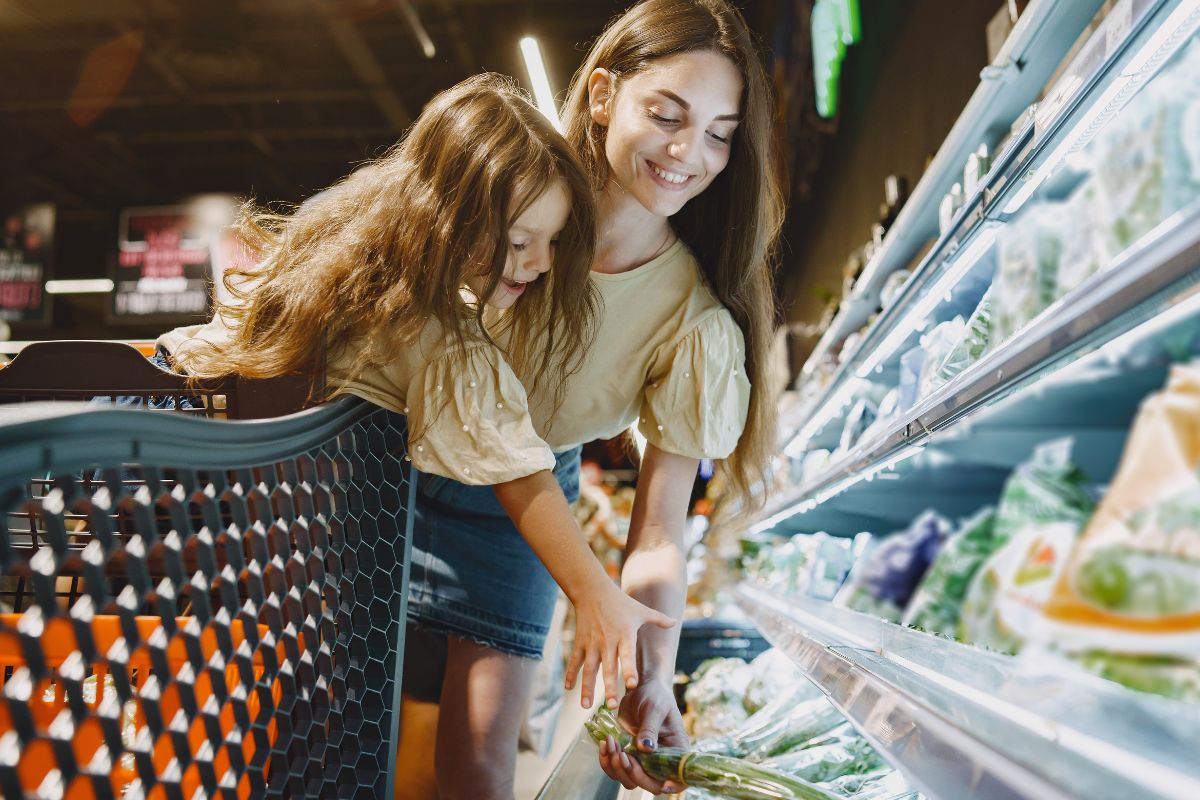 Mother and daughter shopping for groceries together in a supermarket.