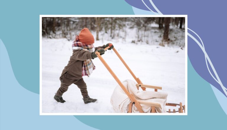 Child dressed in warm winter layers pushing a sled in the snow, showing smart packing and staying warm during winter travel with kids.
