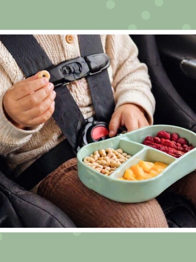 Toddler in a car seat eating a healthy snack from a divided container, showing easy and mess-free road trip snack ideas for kids.