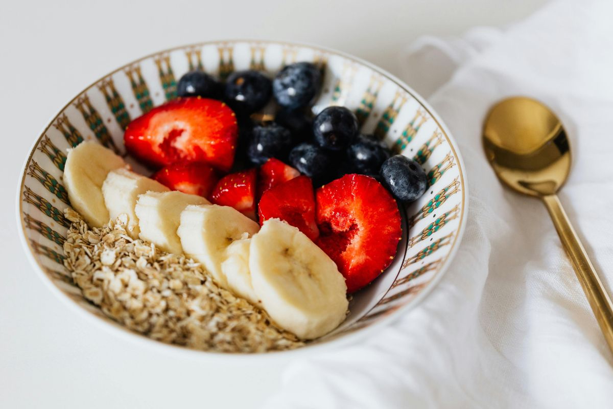Bowl of oatmeal with banana, strawberries, and blueberries, a simple and healthy toddler snack idea for road trips.