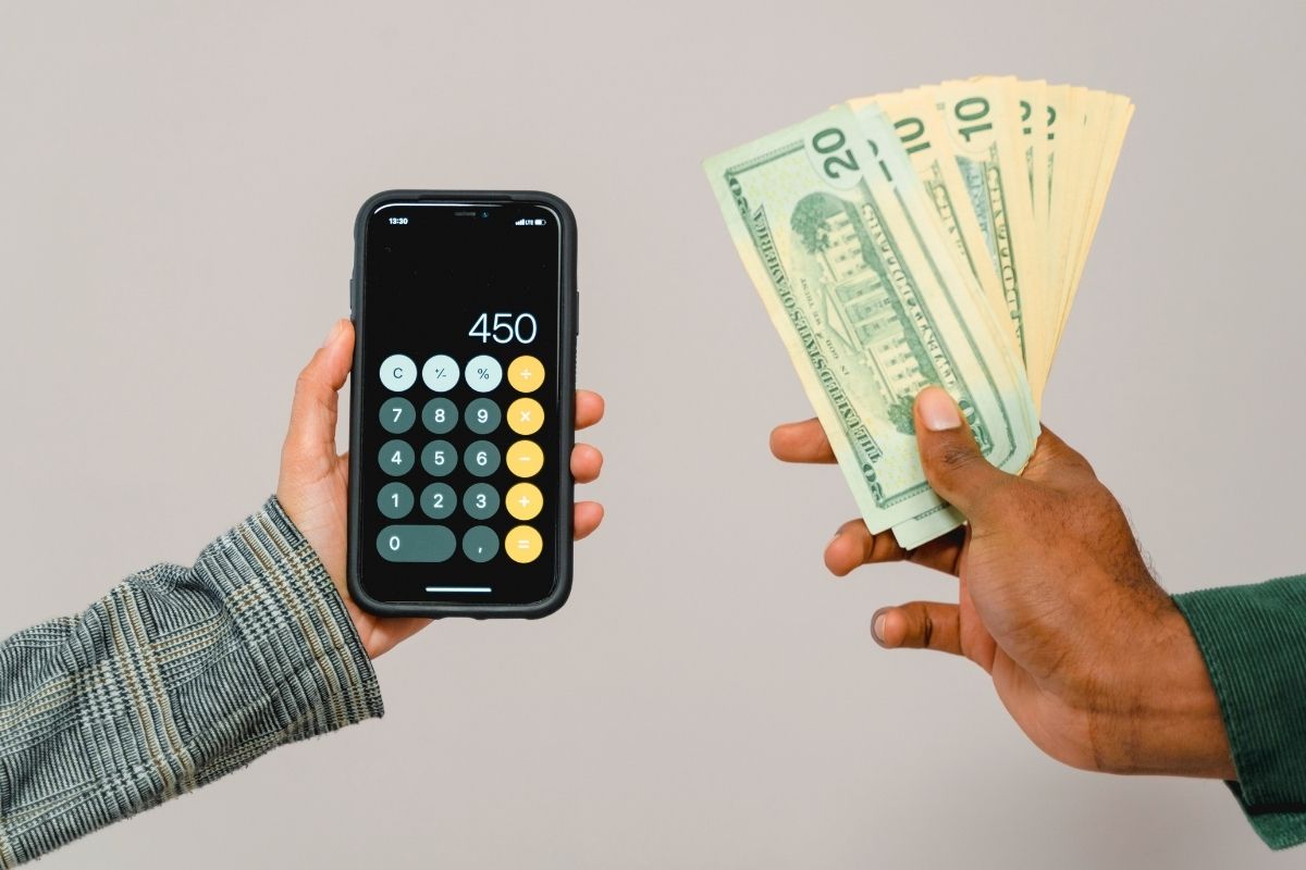 Using calculator and cash to manage grocery budget.