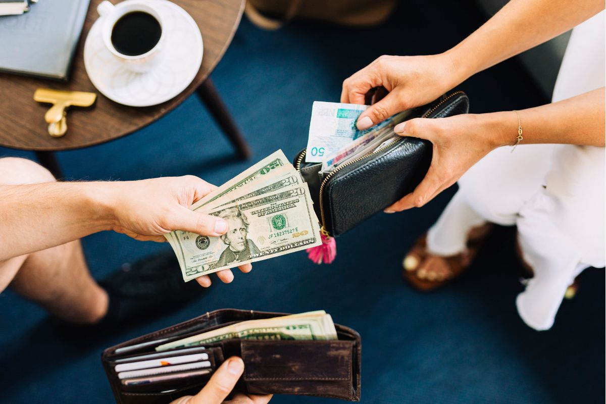 Hands exchanging cash from a wallet showing real-life spending and money habits.