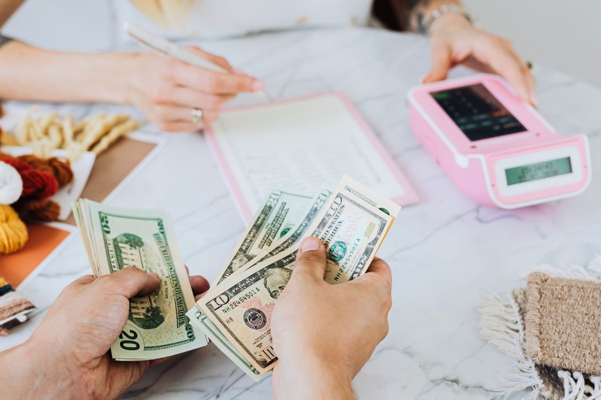 Parent counting cash while teaching kids about money, budgeting, and saving habits.