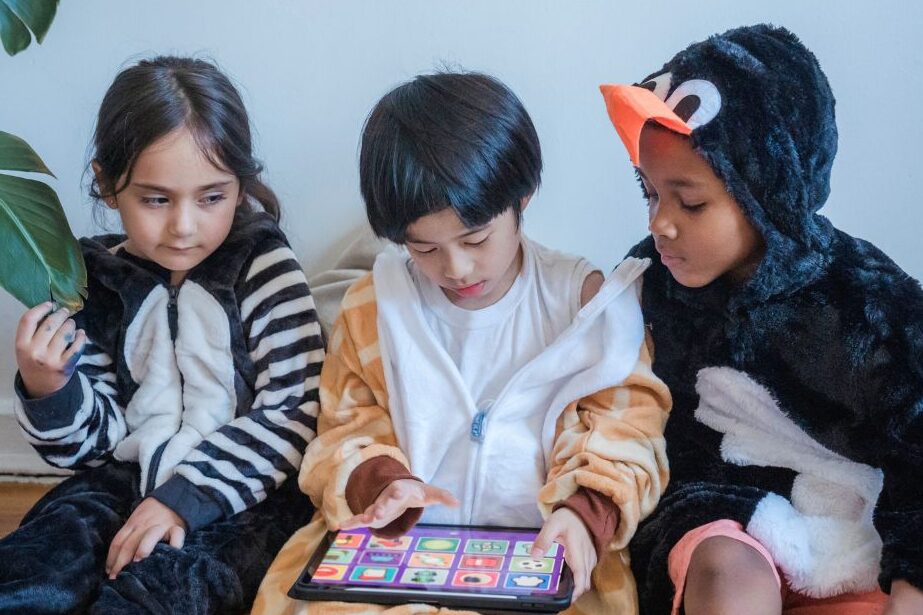 Kids sharing a tablet while learning healthy screen time habits at home.