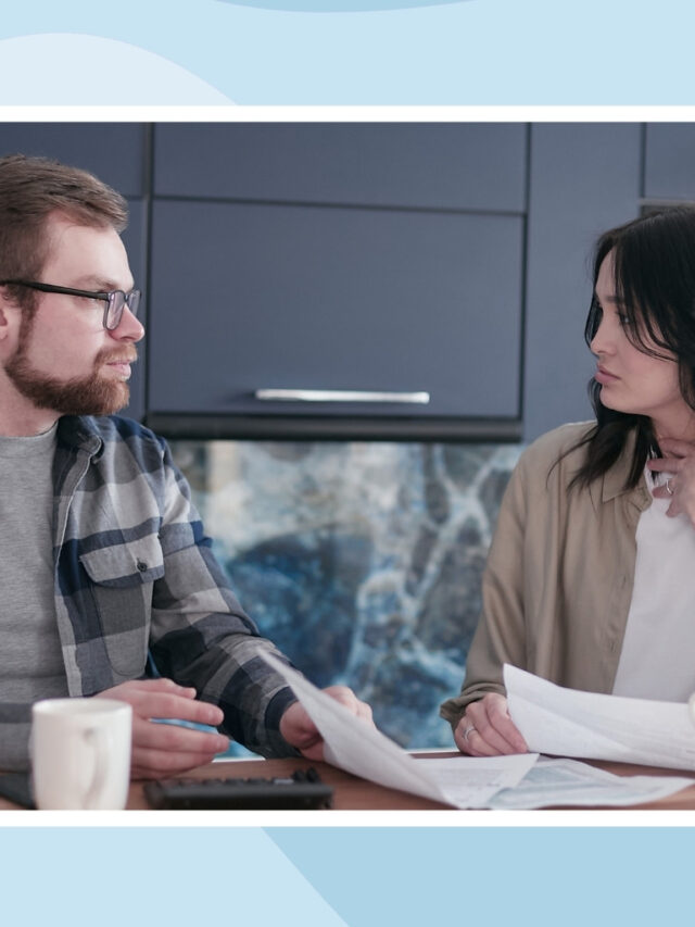 Couple discussing bills and household responsibilities together at the kitchen table.