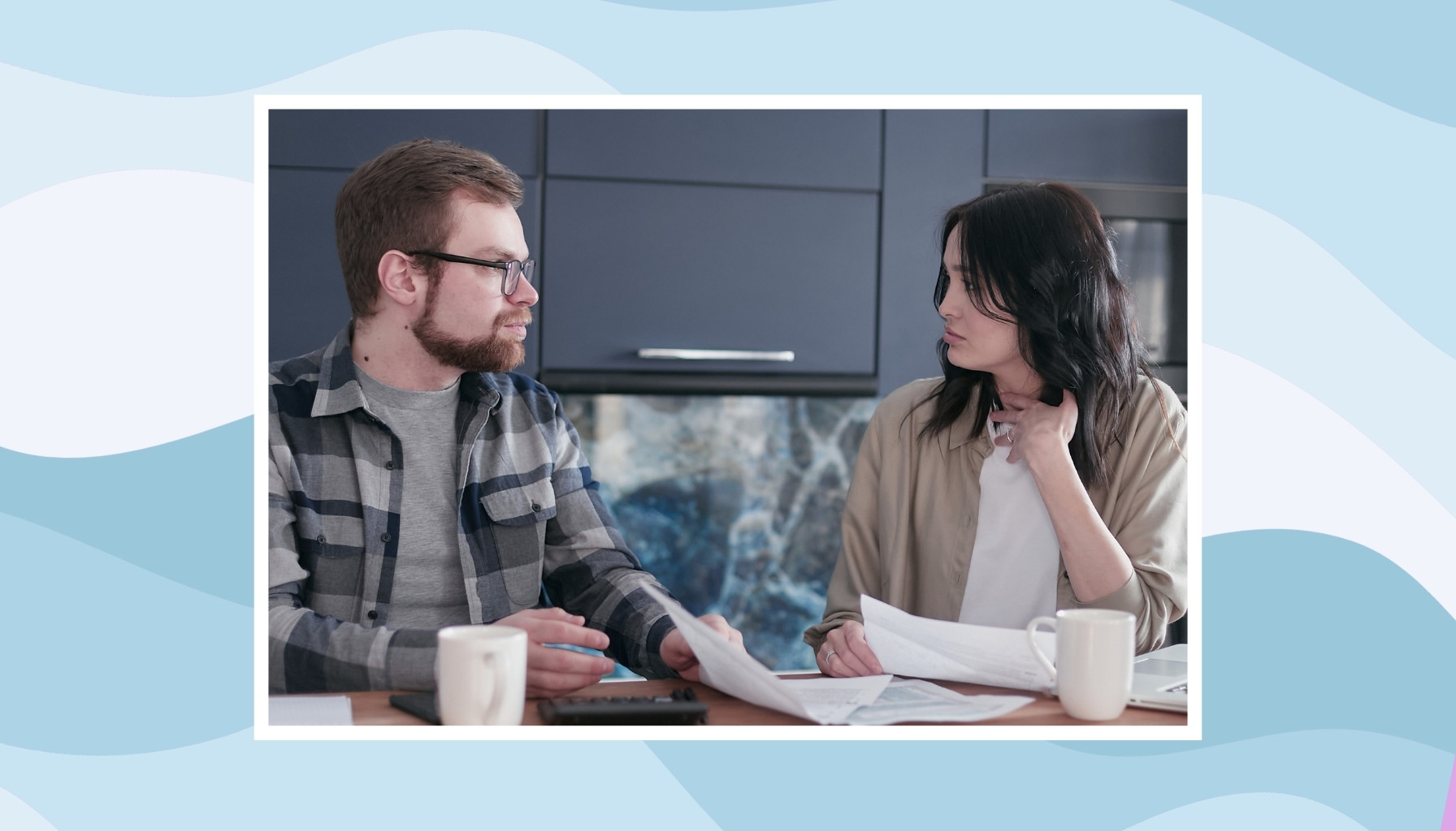 Couple discussing bills and household responsibilities together at the kitchen table.