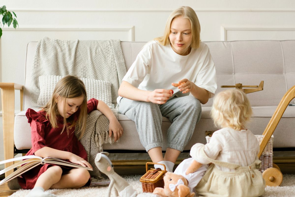 Mother spending time with her two young children at home while adjusting to the changes of everyday family life after becoming a parent.